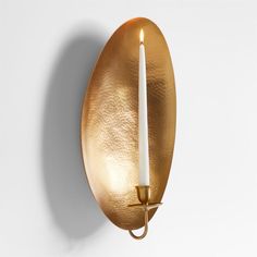 a wall light with a candle in it on a white background and an oval shape