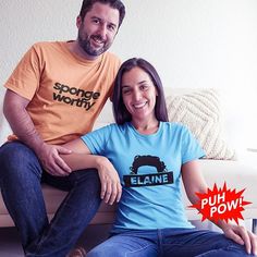 two people sitting on a couch smiling at the camera and one person wearing an orange t - shirt