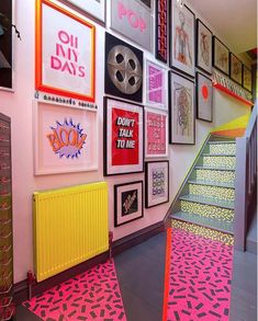 the stairs are decorated with colorful posters and pictures on the wall above them is a yellow radiator