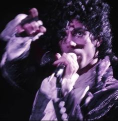 a man with curly hair holding a microphone