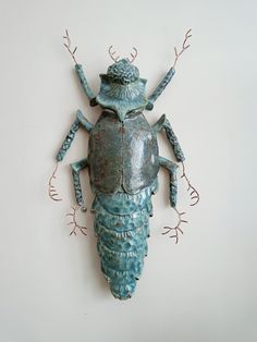 a metal bug mounted to the side of a wall