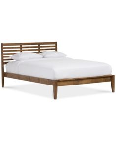 a wooden bed frame with white sheets and pillows