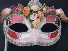 Handmade Venetian Masquerade mask covered in different shades of pink. Silver braid outlines each eye and pearls are found at the corner of each eye. The top of the mask is outlined by fabric flowers and the crown has a silver braid set by a pearl in the middle. the shadings are all separated by pearl beading. The mask is outlined with silver trim for an exquisite finish. Can come with a ribbon covered stick to hold from or tie back ribbons. This type of mask would look lovely on any Bride or br Pink Hatinator, Wedding Masquerade, Mask Flower, Venetian Wedding, Mardi Gras Masquerade, Mother Of The Bride Hats, Masquerade Wedding, Venetian Masquerade Masks, Kentucky Derby Fascinator