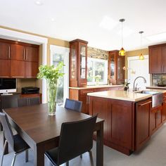 a large kitchen with wooden cabinets and an island in the middle, along with a dining room table