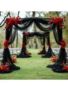 an outdoor ceremony with red flowers and black drapes