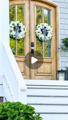 two wreaths on the front door of a house