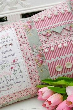 pink tulips are sitting next to a pillow on a bench with a message