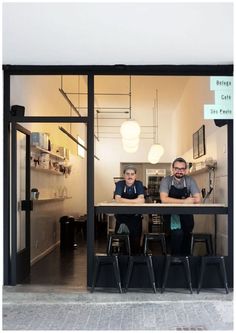 two men sitting at a table in front of a store