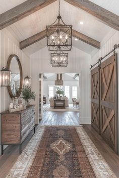 a large foyer with wooden doors and chandelier hanging from it's ceiling