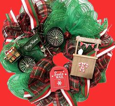 a christmas wreath with an old fashioned toy car and mailbox attached to it on a red background