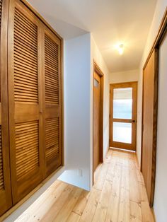 an empty hallway with wooden shutters and wood flooring on both sides is seen in this image