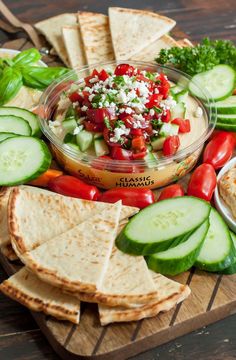 a platter filled with sliced cucumbers, tomatoes, and other veggies