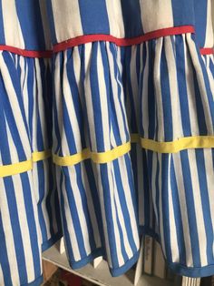 "Whimsical and fun! Cheerful royal blue vertical stripes with accent trims of red and yellow. *Belt not included Measurements: 33\" bust 23\" waist unstretched 34\" waist stretched 8-1/4\" from underarm to waist 23\" from waist to hem 4-18\" spaghetti straps 46\" flared hips 32\" from top of back to hem" Retro Striped Lined Dress, Blue Cotton Dress With Vertical Stripes, Strapped Dress, Yellow Belt, Red And Yellow, Sun Dress, Vertical Stripes, Fort Lauderdale, Strap Dress