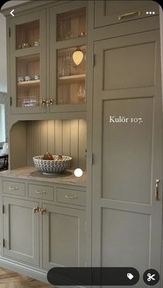 an image of a kitchen setting with cabinets and bowls on the counter top in front of it