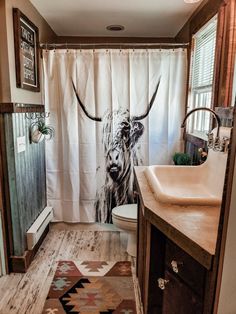 a bathroom with a cow shower curtain next to a sink