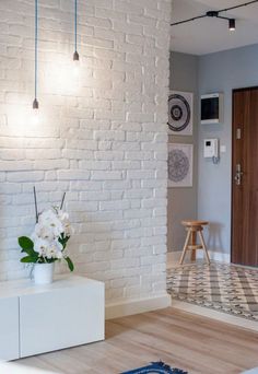 an image of a room with white brick walls and wood flooring in the background