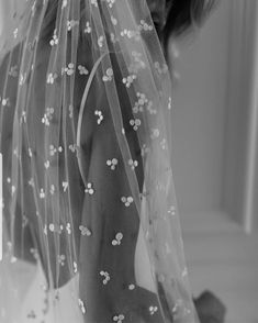 black and white photograph of a woman wearing a wedding veil with flowers on the side