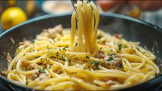 a fork is being used to stir spaghetti in a bowl