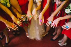 a group of women in red dresses holding their hands together with painted nails on them