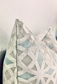 a white and blue pillow sitting on top of a bed