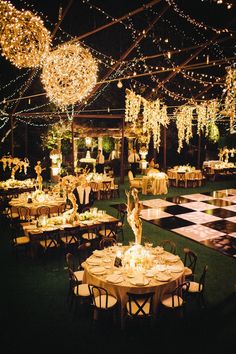 an outdoor event with tables and chairs covered in lights