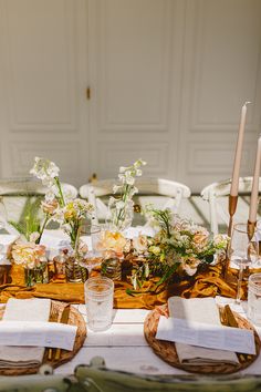 the table is set with flowers and candles