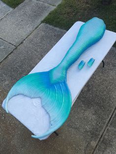 a blue and white surfboard with a mermaid tail