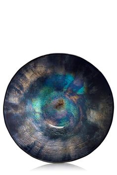 a black plate with blue and green swirls on the rim, against a white background