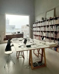 a room with many bookshelves and tables in it