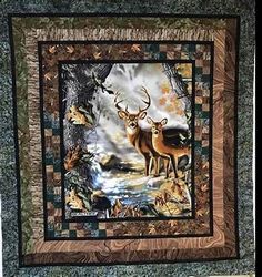 a quilted wall hanging with two deers in the woods