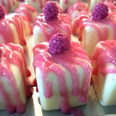 small desserts with raspberries and white chocolate drizzled on them