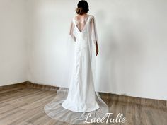 a woman in a white wedding dress standing on a wooden floor