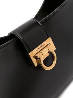 Trifolio shoulder bag from SALVATORE FERRAGAMO featuring adjustable shoulder strap, matte finish, gold-tone hardware, engraved logo, foldover top, main compartment, internal zip pocket and Gancini plaque. Size Info UNI Color Detail Black Made In Italy Material Calf Leather 100% Season One Fall-Winter Season Two Fall-Winter Product bags.. Brand Ferragamo Size And Fit Width 11,81 in / 30 cm Height 7,48 in / 19 cm Depth 2,76 in / 7 cm Handle 9,84 in / 25 cm Luxury Rectangular Shoulder Bag With Logo Plaque, Timeless Business Shoulder Bag With Gold-tone Hardware, Designer Crossbody Bag With Logo Hardware, Gold Satchel With Metal Hardware For Business, Luxury Shoulder Bag With Logo Plaque For Business, Rectangular Gold Shoulder Bag With Logo Plaque, Gold Travel Bags With Logo Hardware, Designer Business Shoulder Bag With Gold-tone Hardware, Modern Business Flap Bag With Gold-tone Hardware