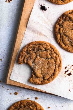 chocolate chip cookies on a cutting board with one cookie cut in half and the other half eaten