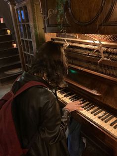 a person sitting at a piano playing it