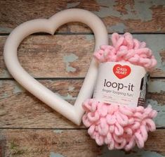 a heart shaped object with pink yarn on it and a tube of toothpaste next to it