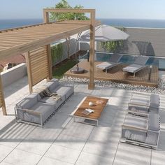 an outdoor living area with couches and tables next to the pool, overlooking the ocean