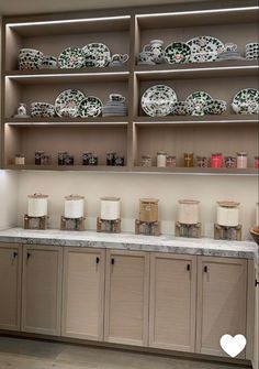 the shelves are filled with dishes and cups on them, along with other kitchen items