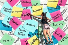 a woman climbing up the side of a ladder covered in post it notes that read help