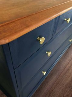 a blue dresser with brass handles and knobs