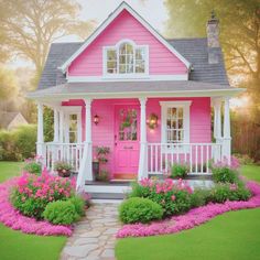 a pink house with flowers in the front yard