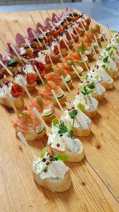 a wooden table topped with lots of appetizers on skewered breads