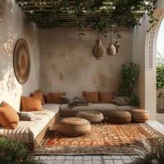 an outdoor living area with couches, pillows and potted plants on the wall