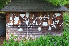 a wooden shed with flowers painted on it