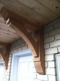 a close up of a wooden shelf on the side of a brick wall near a door