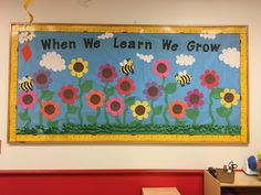 a bulletin board that says when we learn we grow with bees and flowers on it