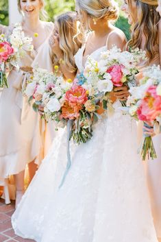 a bride and her bridesmaids are holding bouquets in their hands as they walk down the aisle