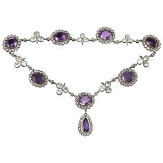 A late Victorian amethyst and rock crystal necklace, the seven oval-shaped amethysts surrounded by a cluster of round-cut rock crystal set in silver to yellow gold, each cluster separated with a rock crystal folitate trefoil, the centre cluster suspending a pear-shaped amethyst and rock crystal drop,the amethysts estimated to weigh 60 carats in total, mounted in gold and silver, circa 1880, measuring approximately 40 x 2.2cm, gross weight 62.5grams. A gorgeous and dramatic amethyst and crystal n Luxury Purple Round Necklace, Amethyst Rock, Rock Crystal Necklace, 1st Dibs, Purple Necklace, Gold Bar Necklace, Cluster Necklace, Amethyst Jewelry, Crystal Set