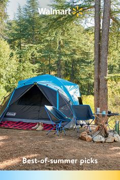 a blue tent sitting in the middle of a forest