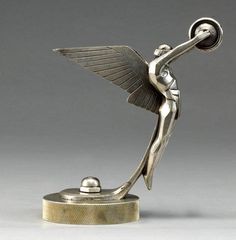 a silver figurine holding a ball on top of a table